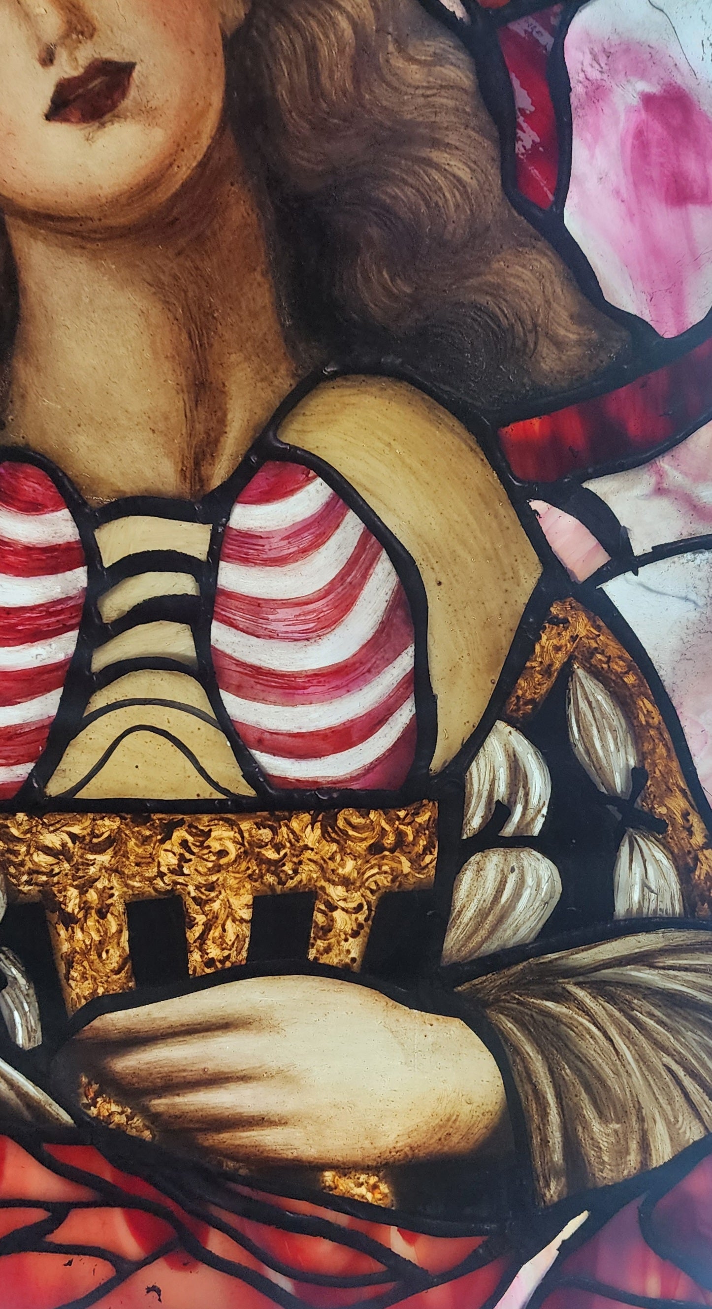 Close-up of a detailed painting with a person wearing a striped garment and gold accents.